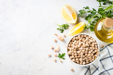 Chickpeas in white bowl at light kitchen table.