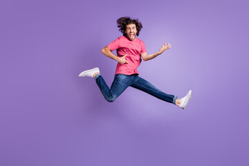Fototapeta na wymiar Full length photo of excited cool young guy dressed pink outfit jumping high playing guitar isolated purple color background