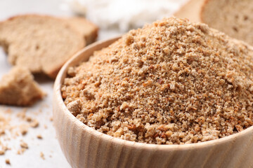 Fresh bread crumbs in bowl on table, closeup