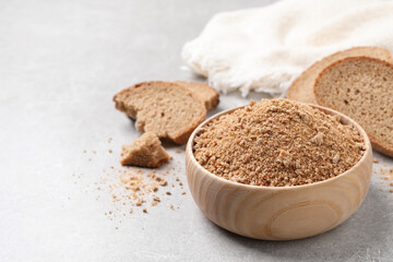 Fresh bread crumbs in bowl on grey table
