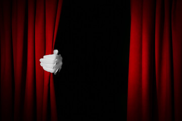 Person opening red front curtains on black background, closeup. Space for text