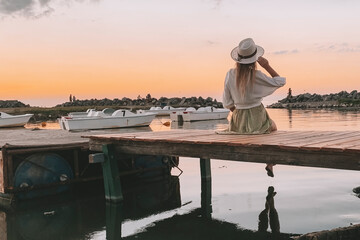 woman staring at a sunset by the lake