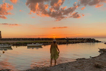 woman staring at a sunset by the lake