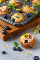 Muffin cupcake with blueberry lemon zest and mint on grey background