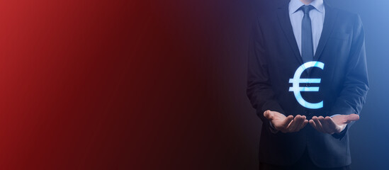 Businessman holds money coin icons EUR or Euro on dark tone background..Growing money concept for business investment and finance