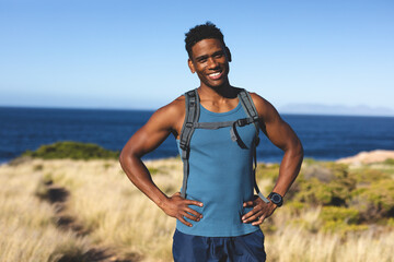 Portrait of fit happy african american man exercising outdoors in countryside to camera