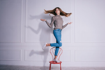 Positive woman tossing hair in studio