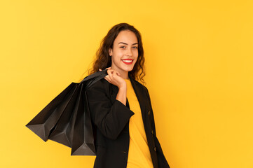 Pretty young woman smiling and happy with shopping bags