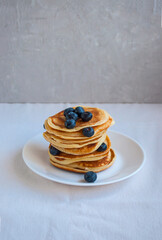 Freshly cooked delicious pancakes with honey, walnut, raspberries and blueberries for breakfast.