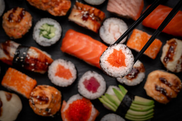 Assorted sushi nigiri and maki big set on slate. A variety of Japanese food with tuna, crab,...
