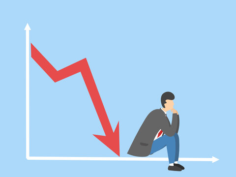 The graph illustrating the stagnation and decline of indicators and a sad businessman is sitting in thought. Bankrupt.