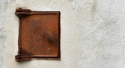 rusty oven door in a plastered wall