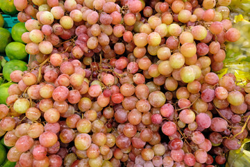 Large pink grapes on the shelves of the store. A bunch of grapes. Delicious grapes close-up.