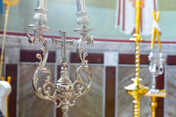 Orthodox faith. Silver cross with blue stones between two candlesticks, an attribute of the...