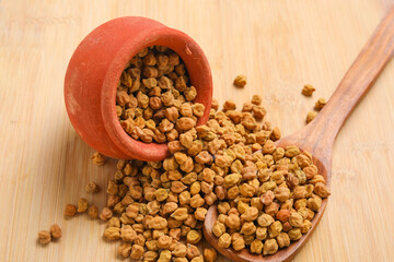 Dried chickpeas in bowl isolated on wooden background.