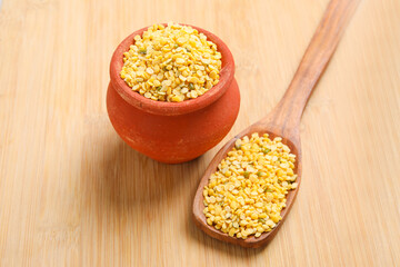 yellow moong mung dal lentil pulse bean in wooden bowl on wooden background.