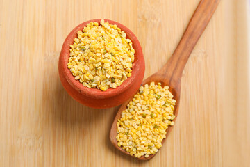 yellow moong mung dal lentil pulse bean in wooden bowl on wooden background.