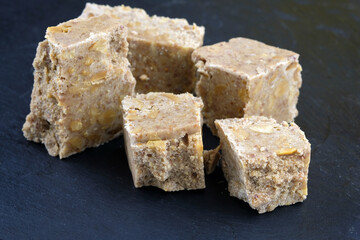 Walnut sherbet on a black slate board. Pieces of peanut sherbet close-up. Peanut sherbet for tea.