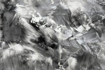 Abstract black-white background. Smears of white and black paint on the canvas, top view. Black and white contrasting paint texture