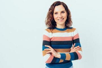 Happy and confident young woman wearing casual striped sweater smiling