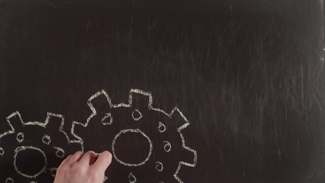 Word the implementation and gears are drawn by hand on a chalkboard. Chalk on blackboard is written with the word implementation and jagged wheels. Idea realization concept.
