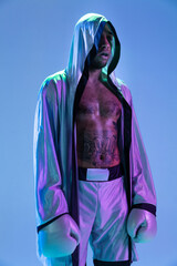 High-fashion styled man in white outfit pacticing box isolted over gradient background in neon light