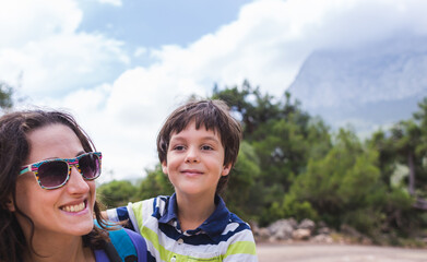 Portrait of a boy with mom on a background of mountains