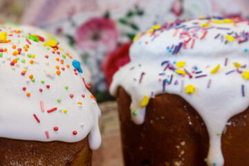 Easter spring holidays sweet bread, paska close-up composition decorated with sugar icing on blurred background. Orthodox handmade kulich with topping