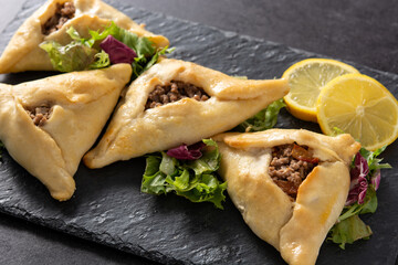 Traditional middle eastern fatayer on black stone	