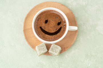 Smiley face shape on a cup of coffee and Turkish delights
