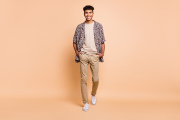 Full size photo of brunet optimistic guy going wear modern shirt trousers sneakers isolated on...