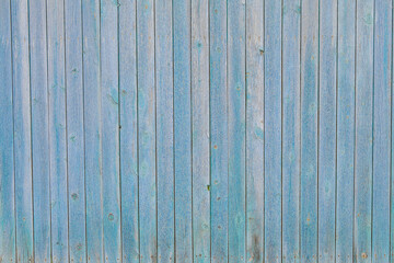 Fototapeta na wymiar Unique texture of old fence boards painted with blue paint
