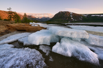 Melting ice on a mountain lake on a sunny spring morning