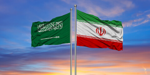 Iran and Saudi Arabia two flags on flagpoles and blue cloudy sky