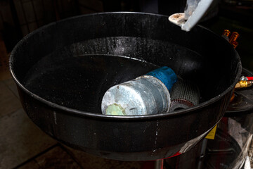 Worn diesel fuel filter, lying in the used car fluid container.