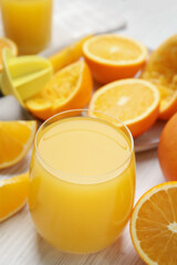 Freshly made juice, oranges and reamer on wooden table