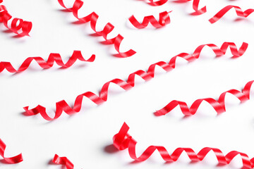 Many red serpentine streamers on white background