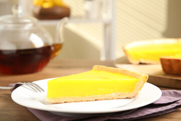 Slice of delicious homemade lemon pie on wooden table