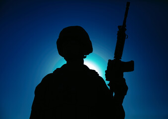 Night silhouette of army special operations forces soldier standing with service rifle on...