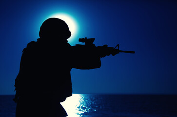 Silhouette of army special forces rifleman, soldier in ammunition and helmet aiming gun, shooting...
