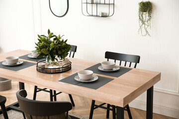 Stylish wooden dining table and chairs in room. Interior design