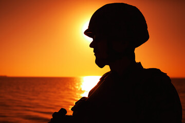 Silhouette of army infantry soldier, special forces rifleman armed with service rifle, patrolling...