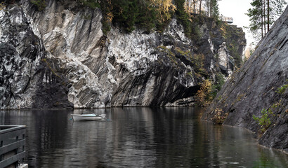 White and turquoise boat in mountain lake natural background. Tourism and hiking concept.