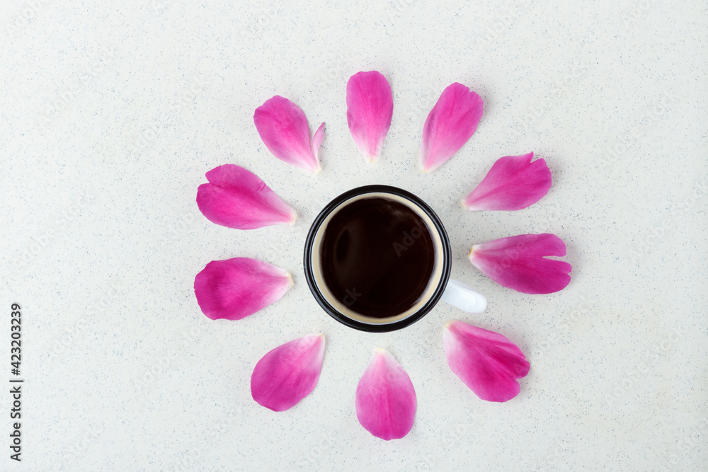 Wall mural Still life with coffee mug and pink peony petals on a light background.