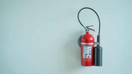 Red fire extinguishers hung on the white wall.