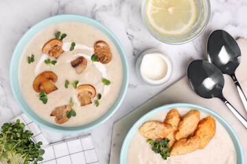Delicious cream soup with mushrooms served on white marble table, flat lay