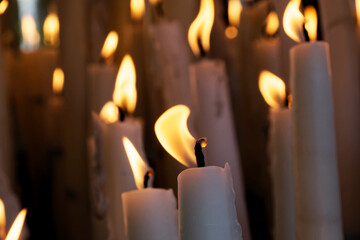 detail of the burning candles next to the basilica of Lourdes, close-up of the candle offerings