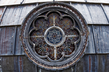 detail of a rose window and its stained glass outside on the dome of the basilica of Lourdes