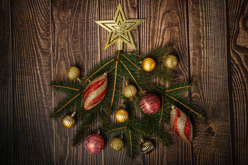 New Year card. Christmas tree made of red and gold Christmas balls, on a wooden background. Flat lay, top view, copy space. New Year sale card. Christmas composition.