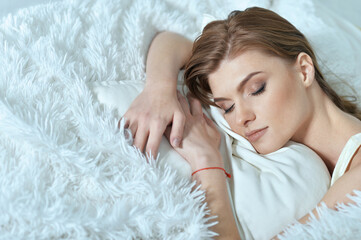 Beautiful young woman lying on soft  bed